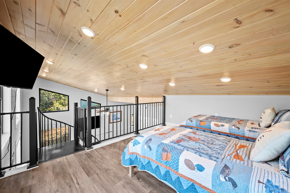 Loft sleeping area with twin beds overlooking the main living space. A favorite spot for kids, offering comfort, fun, and just the right amount of separation while still feeling connected to the rest of the home.
