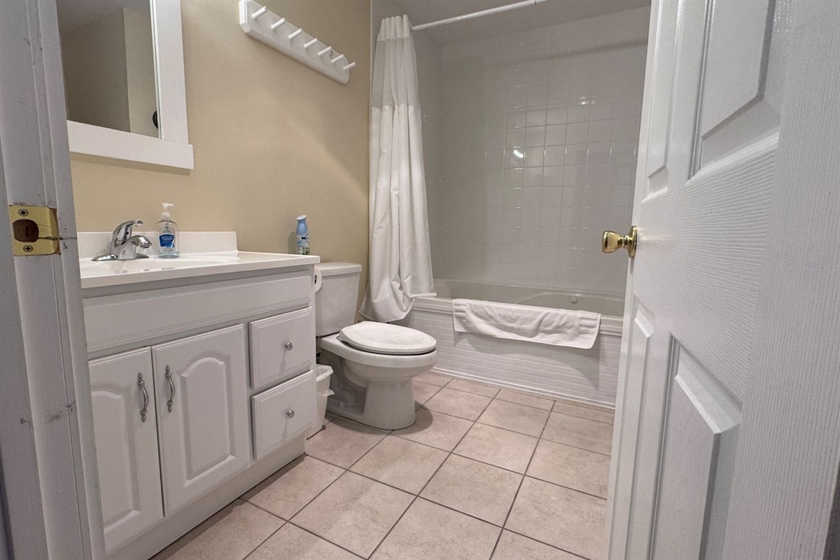 The bathroom has a large jetted tub and shower and a washer and dryer behind the door. 