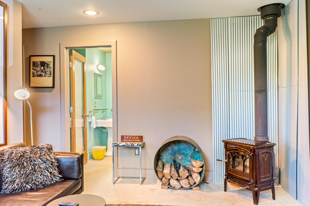 Lower level living area looking toward the dedicated guest bathroom and hallway leading to the twin guest room. This layout creates a private, self-contained suite for kids or secondary groups, away from the main level social hubs.
