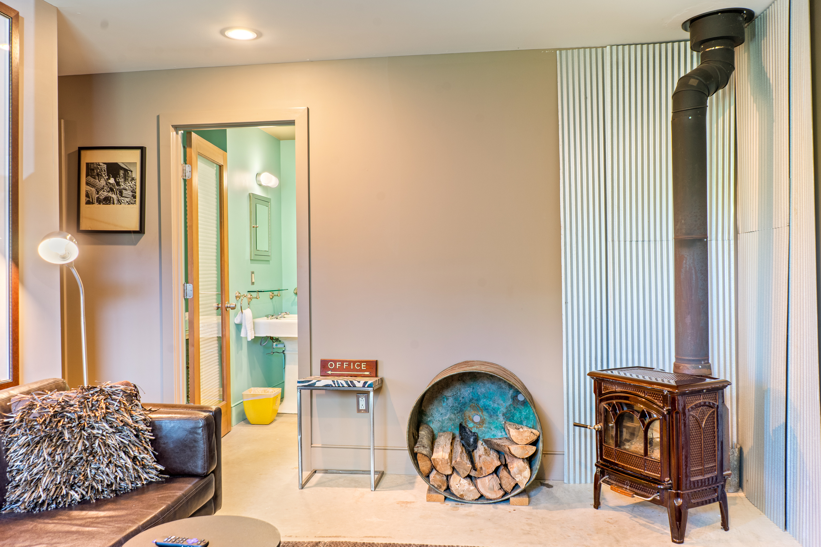 Lower level living area looking toward the dedicated guest bathroom and hallway leading to the twin guest room. This layout creates a private, self-contained suite for kids or secondary groups, away from the main level social hubs.