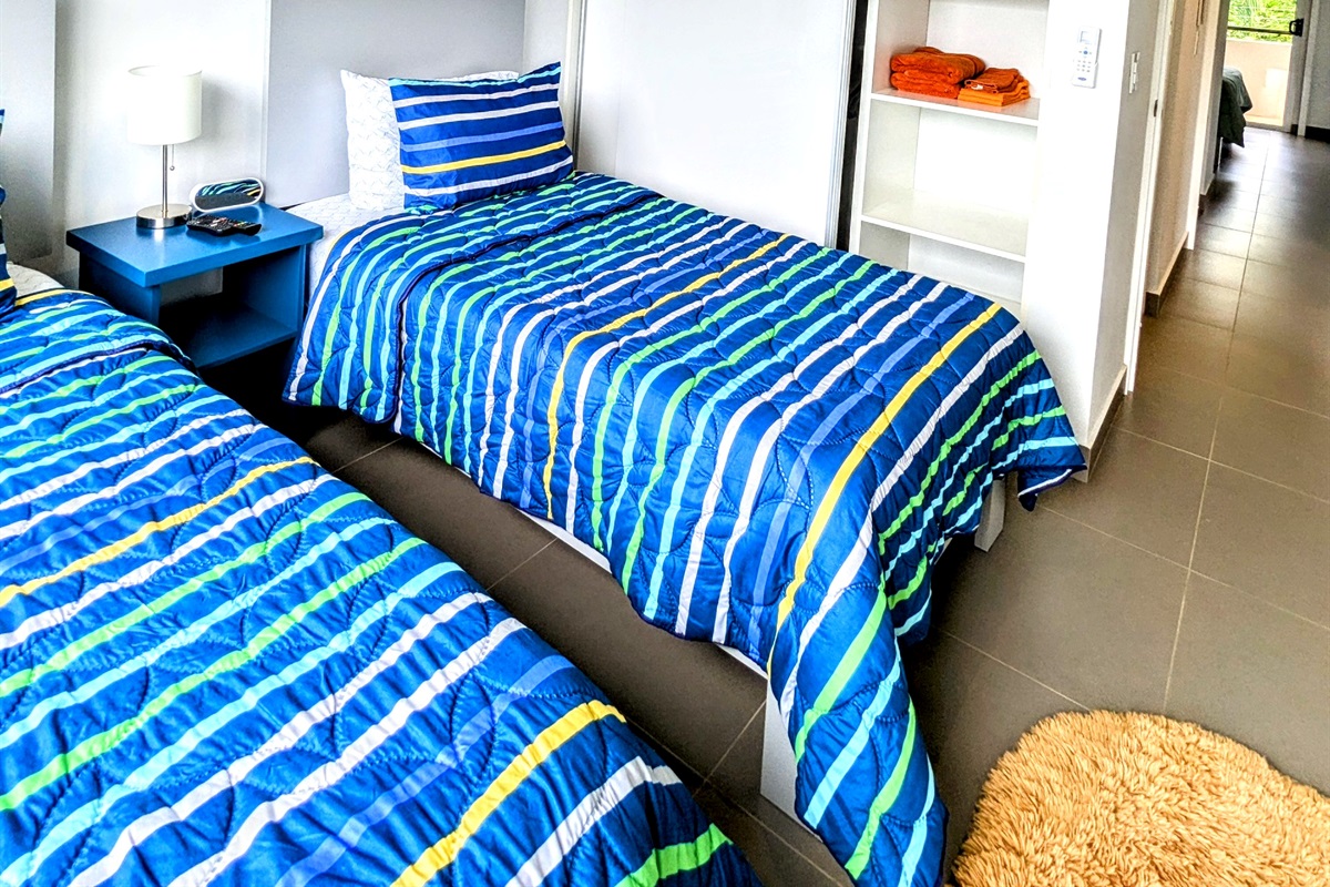 Guest bedroom 2 with two twin beds and ample closet space