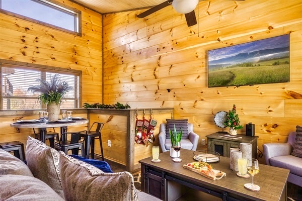 Enjoy a good meal in the cozy dining area of the cabin, surrounded by warm wooden walls and comfy seating. The perfect spot for memorable gatherings with friends and family.