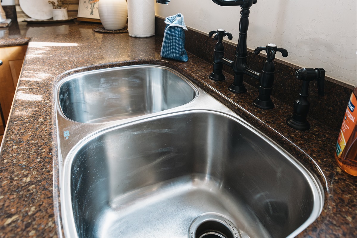 Bright, fully stocked kitchen with double sink, granite counters, and warm mountain touches—perfect for cooking meals together after lake days or ski adventures in Pinetop.