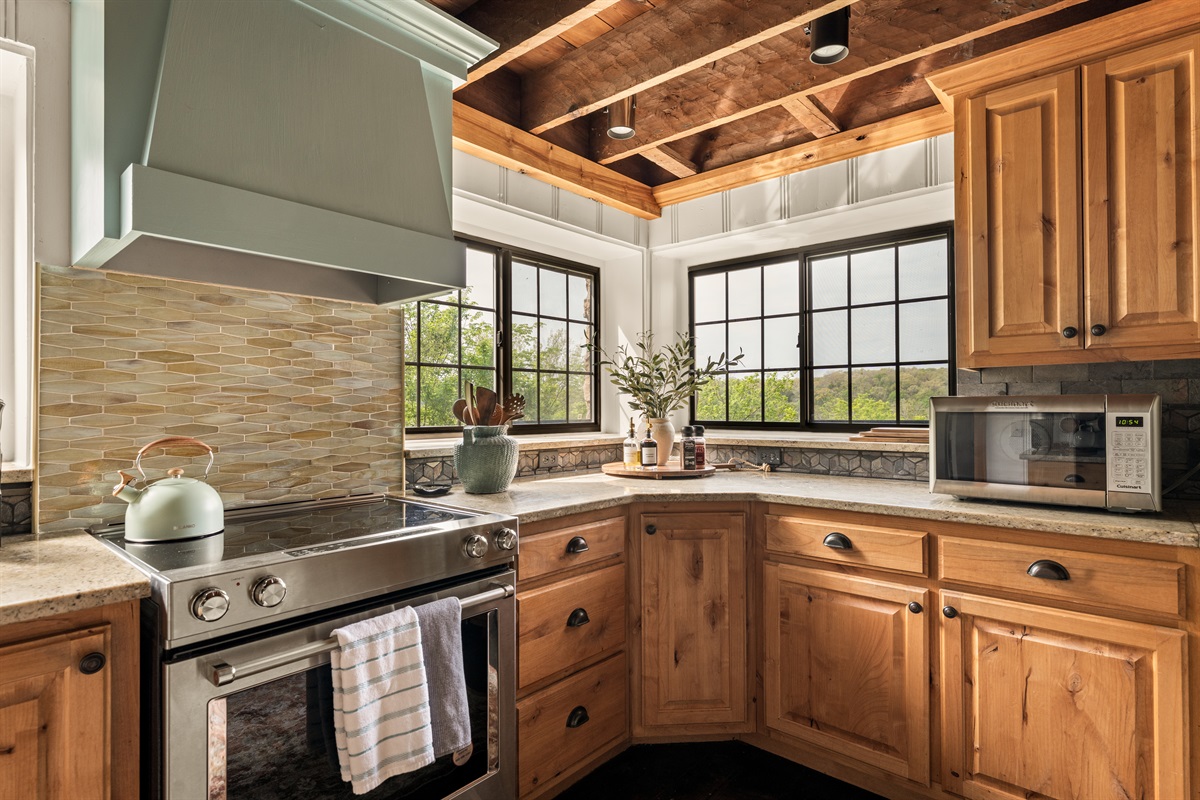 Cook with a view in this light-filled kitchen, featuring warm wood cabinetry and scenic windows.