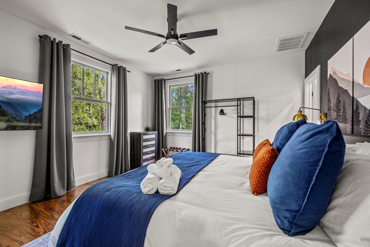 This king suite pairs comfort with dramatic contrast, offering dual windows, dark tones, and warm lighting—your cozy mountain retreat with an ensuite bath.