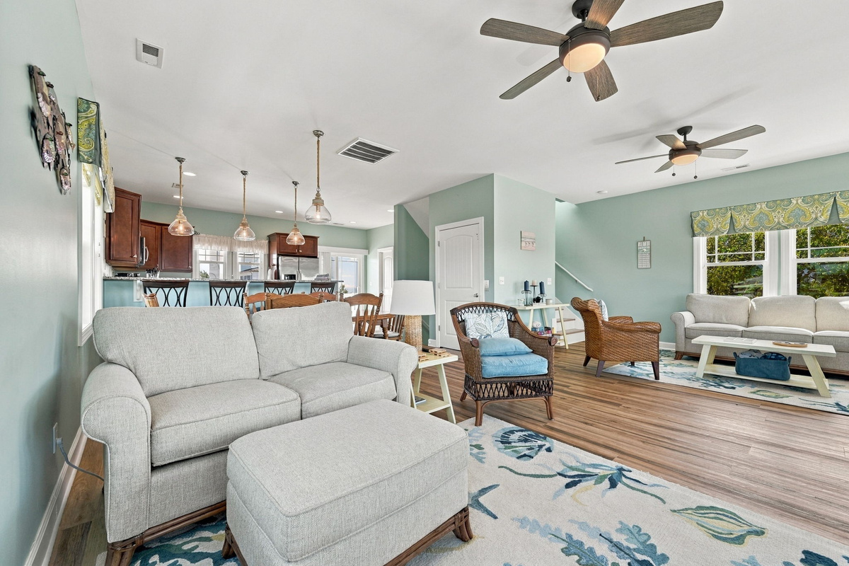 Kick back and relax in the spacious living room featuring plush seating, cheerful coastal décor, and room for everyone to gather