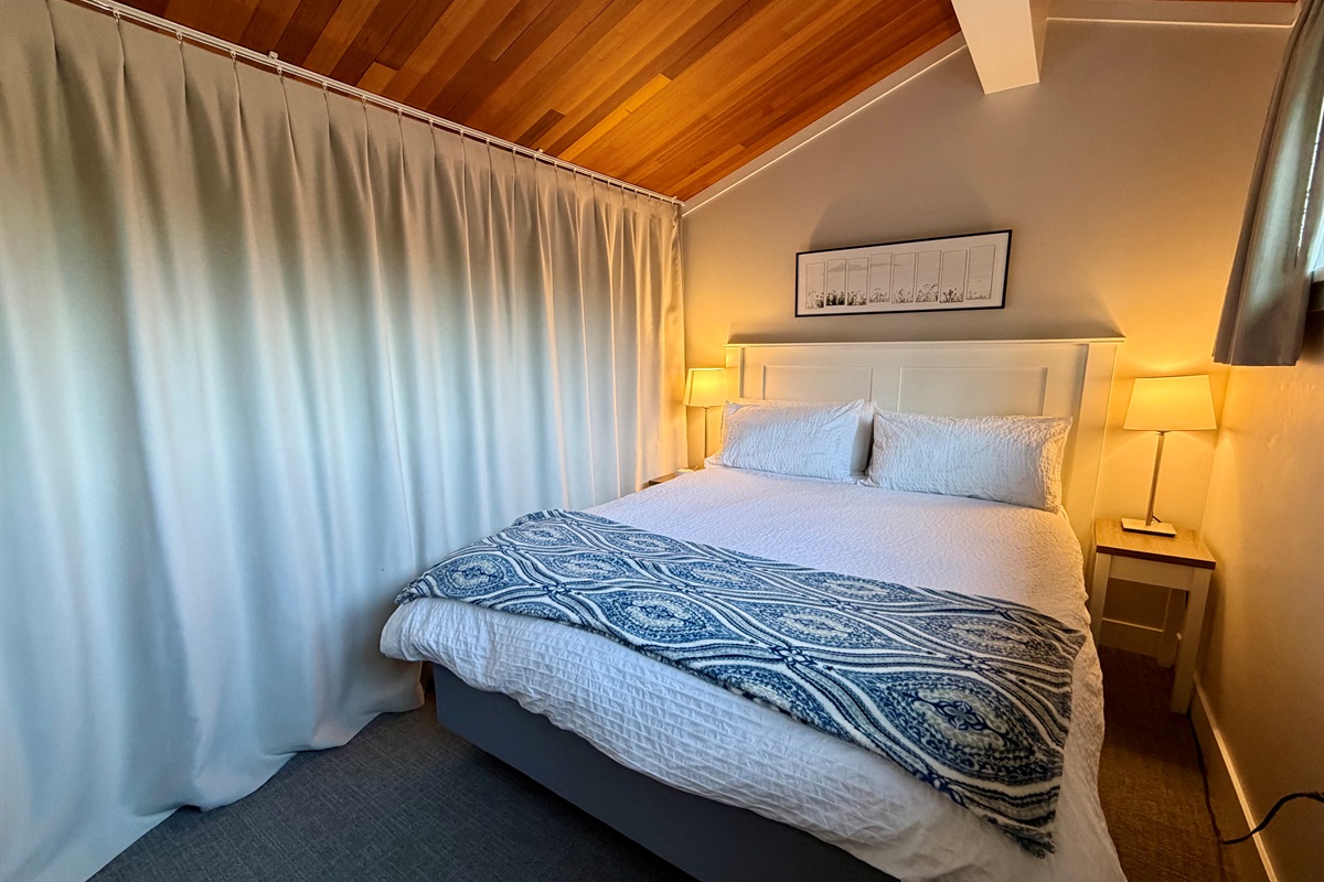 Loft bedroom area with black out privacy curtains.