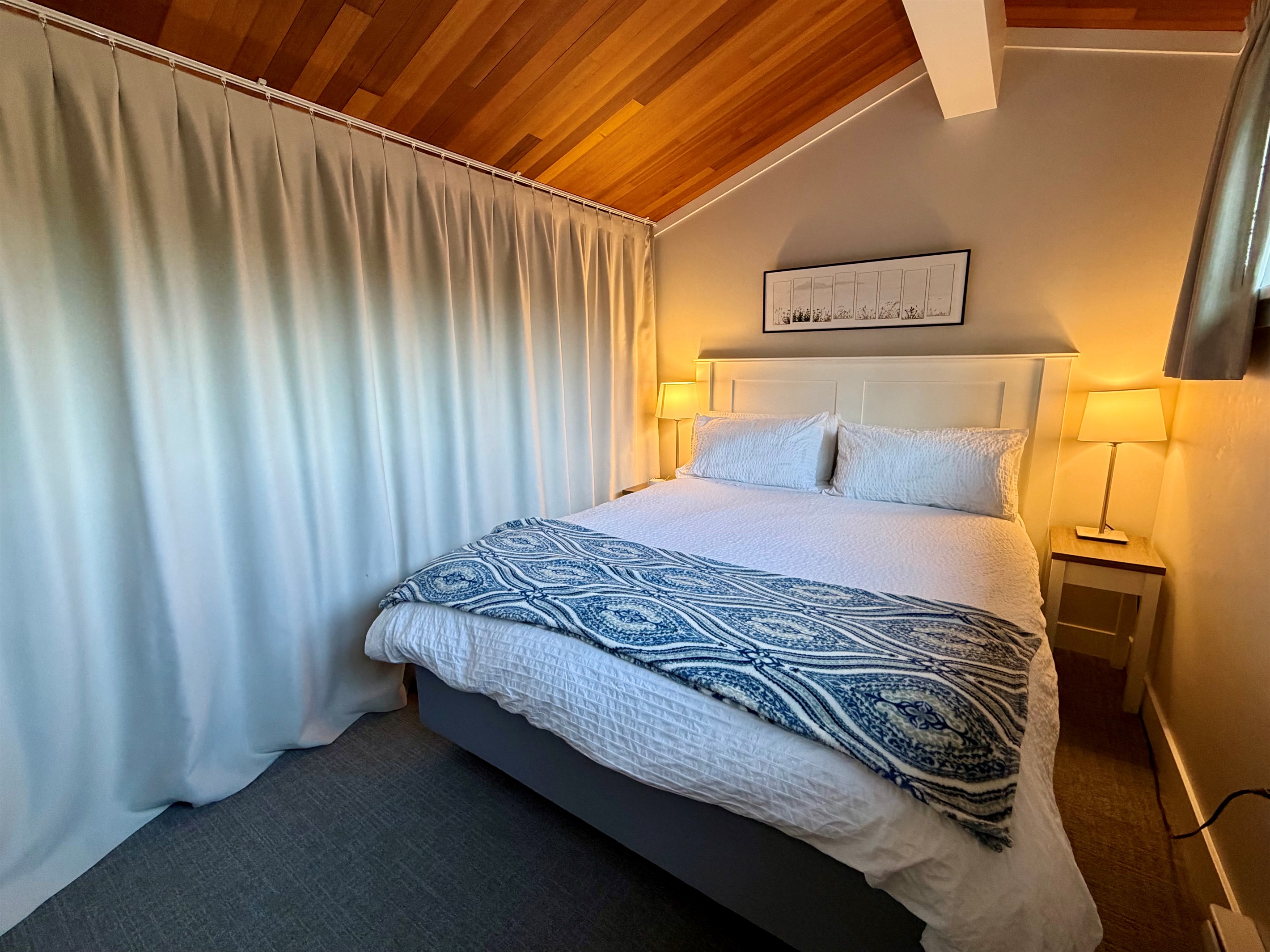 Loft bedroom area with black out privacy curtains.