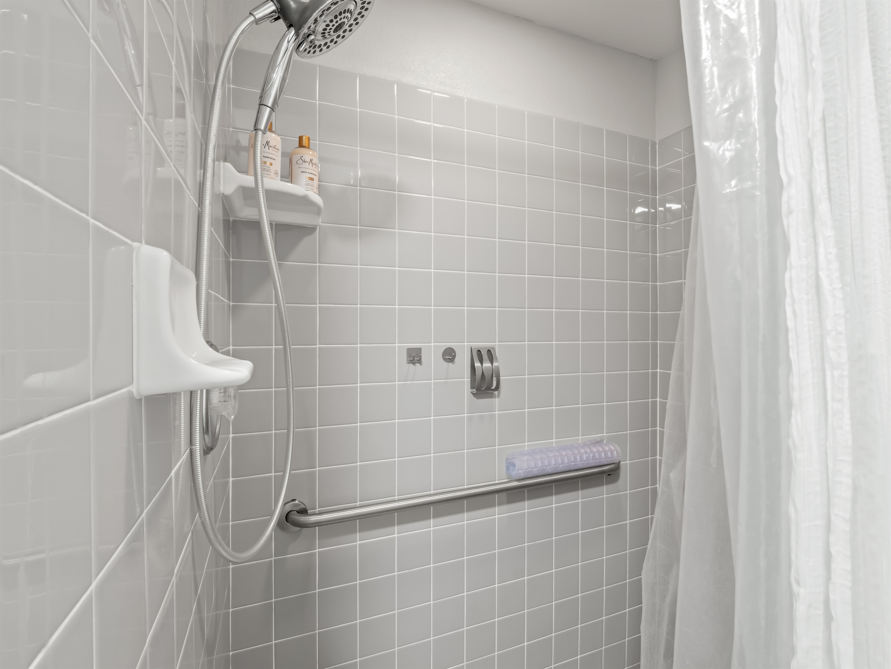 Clean, modern walk-in shower with sleek tile surround, chrome fixtures, and spa-style handheld showerhead—simple, fresh, and designed for a relaxing start or end to your day.
