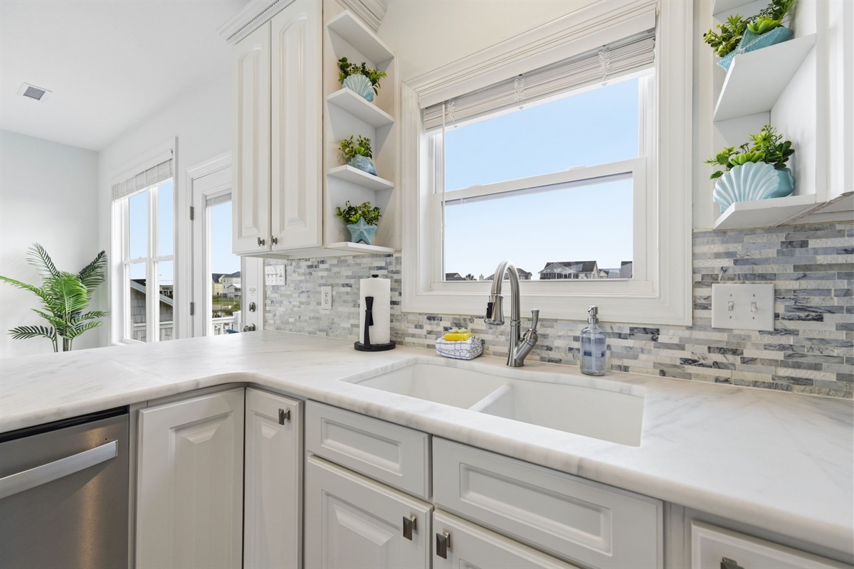 Prep breakfast with natural light pouring into this airy coastal kitchen