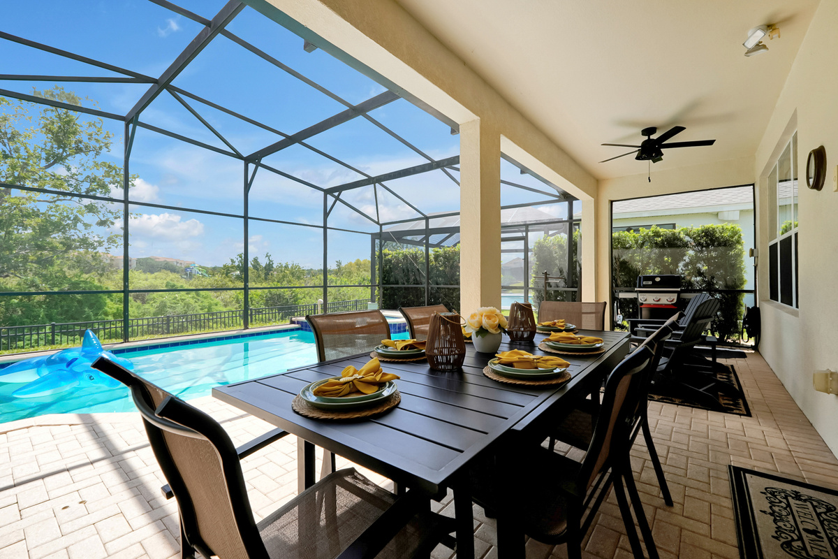 Covered Lanai: Spacious covered outdoor dining area with ceiling fans and seating for the whole family.