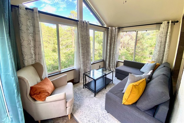Sunroom located off the living room.  This is perfect for relaxing in a quiet space with a view of the outside! The sofa pulls out to a queen size bed for additional sleeping for 2.