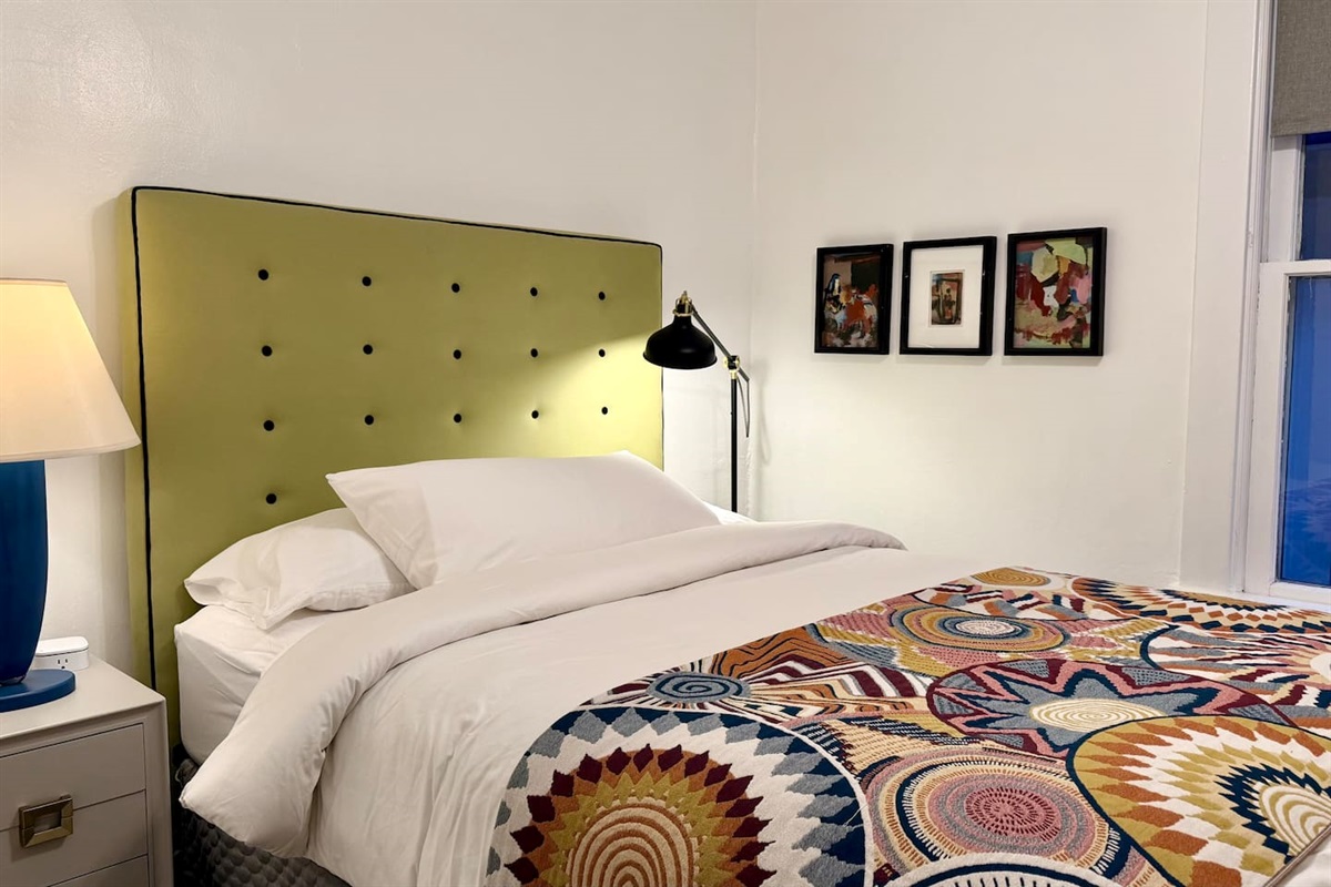 Queen bedroom featuring comfortable luxury mattress, soft cotton linens, bedside lighting with curated design forward furnishings - ideal for extended stays, relocations and professionals.