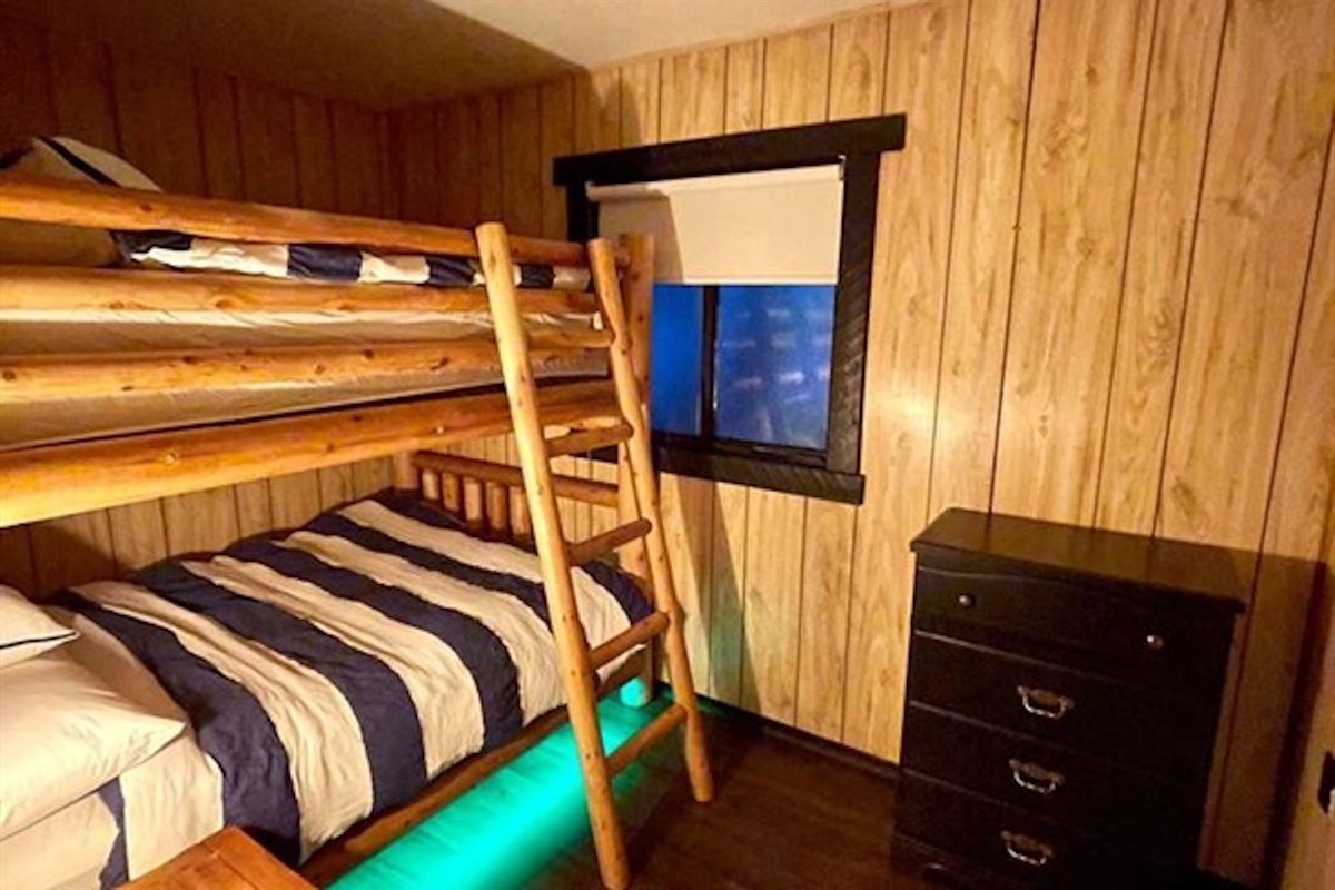 Bunk room with colorful accent lighting and storage