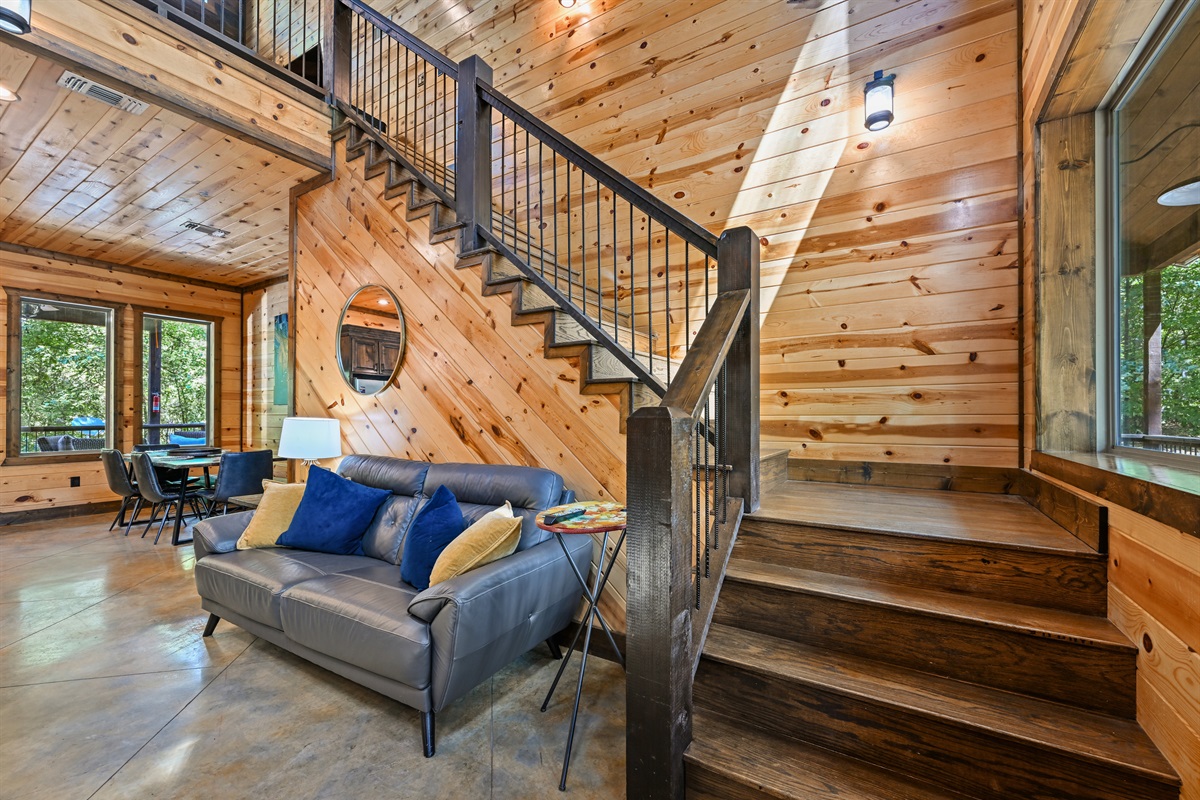 A cozy corner off the staircase adds even more space for guests to gather, relax, or curl up with a book.