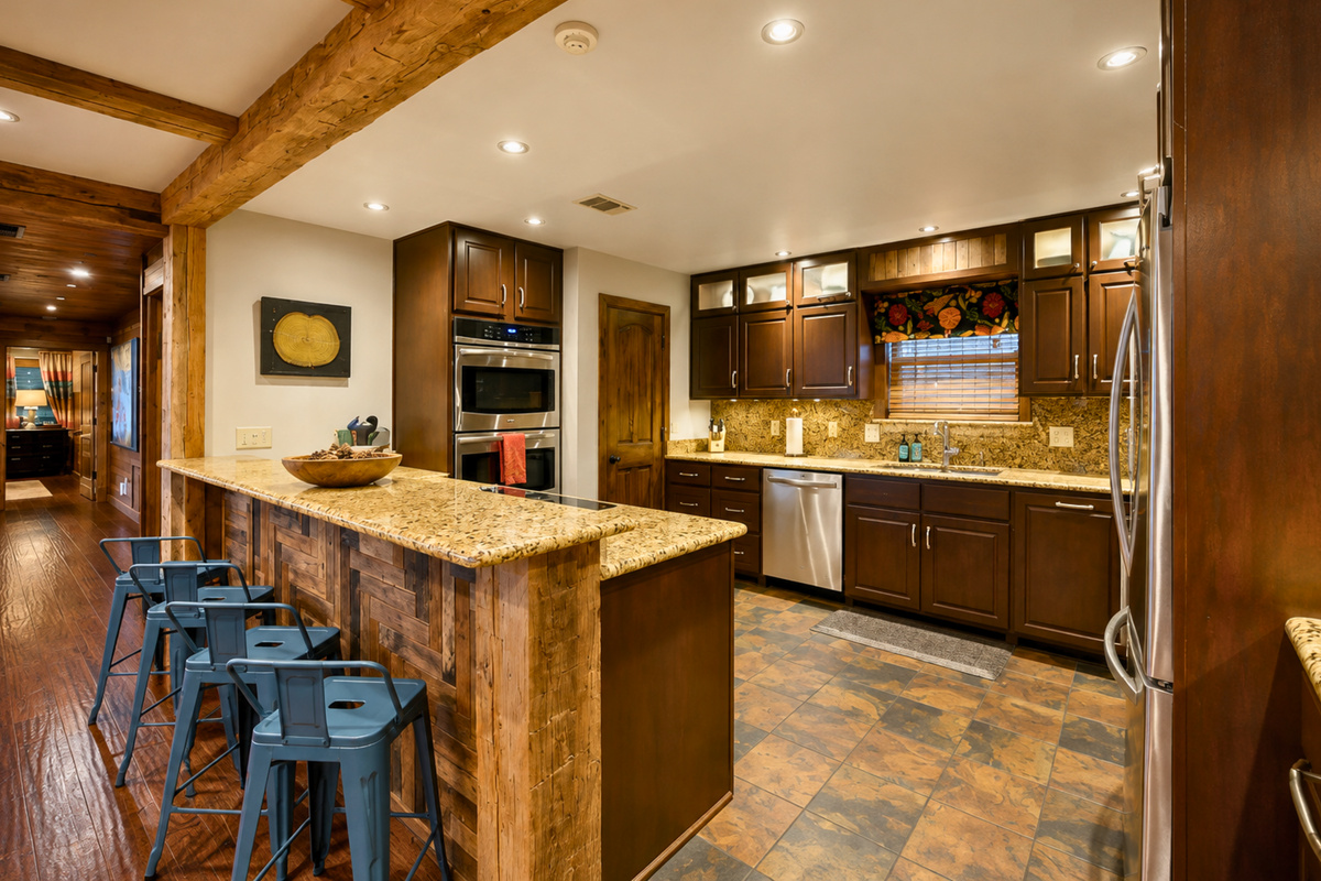 The spacious kitchen offers plenty of room to cook and gather, with generous counter space, bar seating, and warm wood finishes that fit right into the cabin atmosphere.