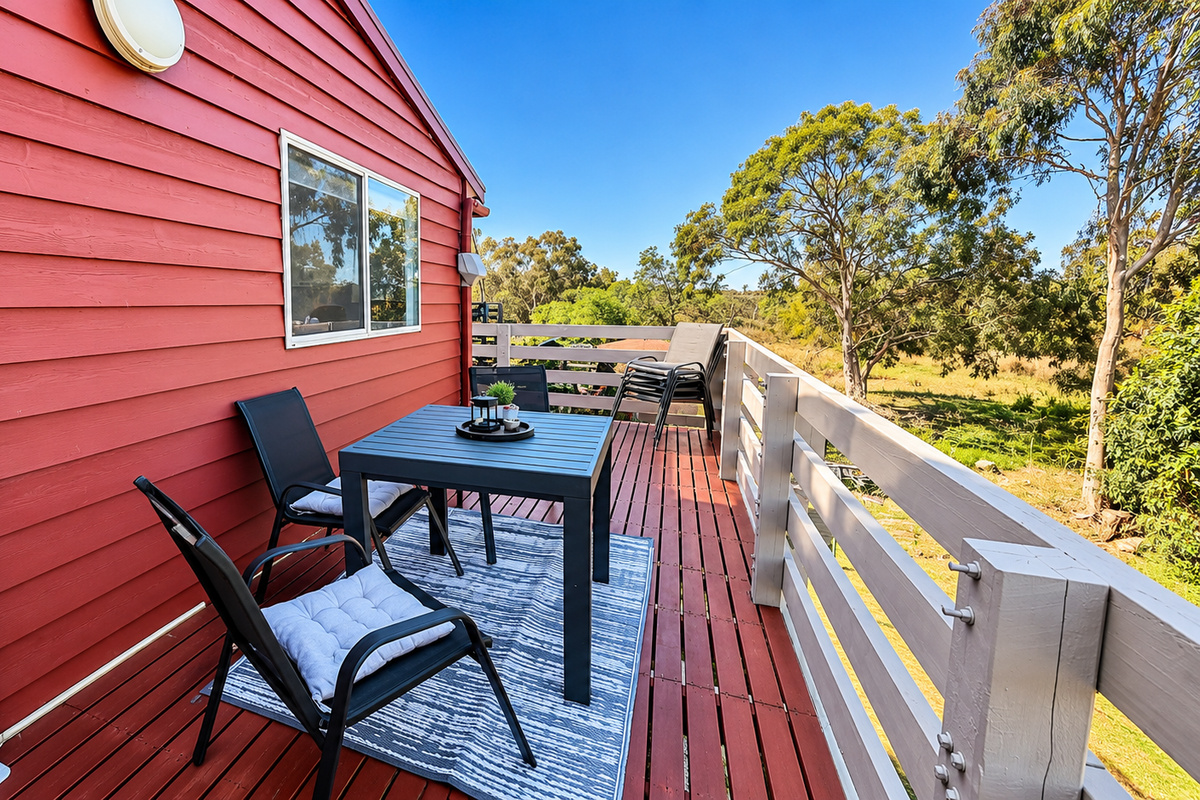 Enjoy the outdoors at Carlenes Getaway with a spacious elevated deck, outdoor dining setting and peaceful views across the surrounding greenery.