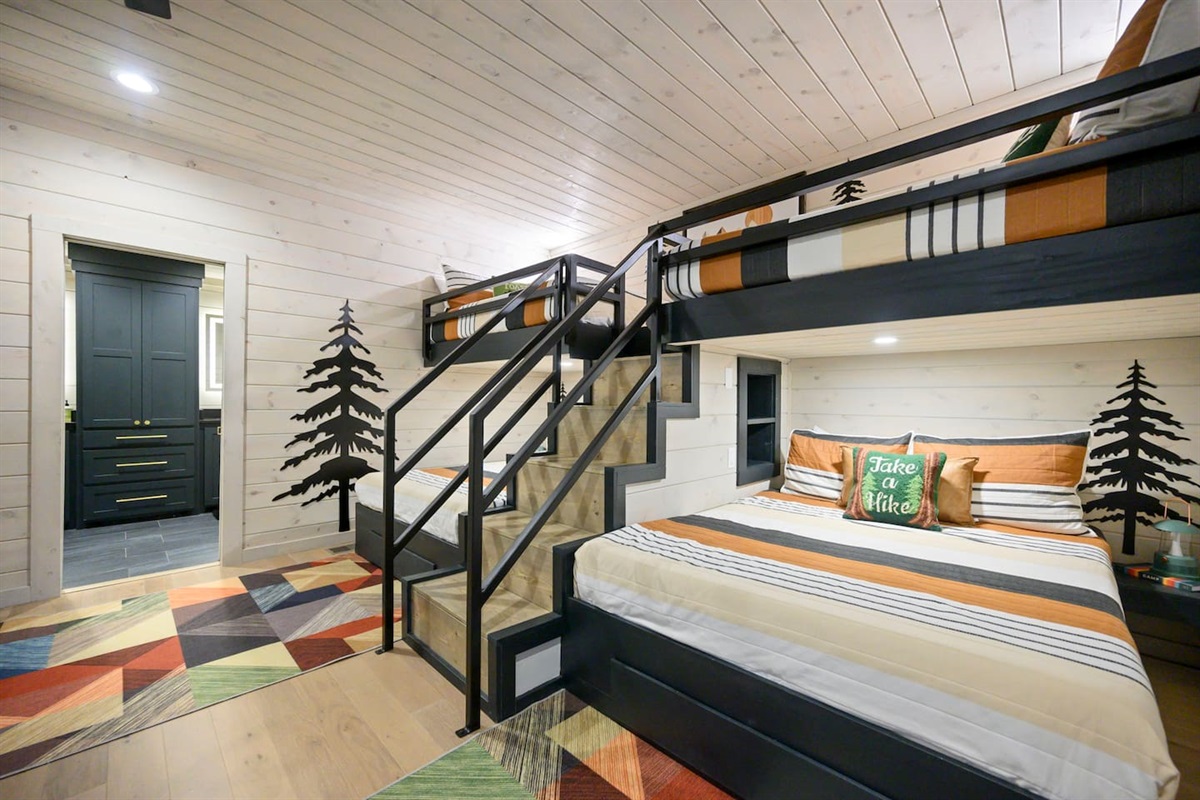 Custom built bunk beds complete with iron railings, charging niches for electronics and lights for each bunk.