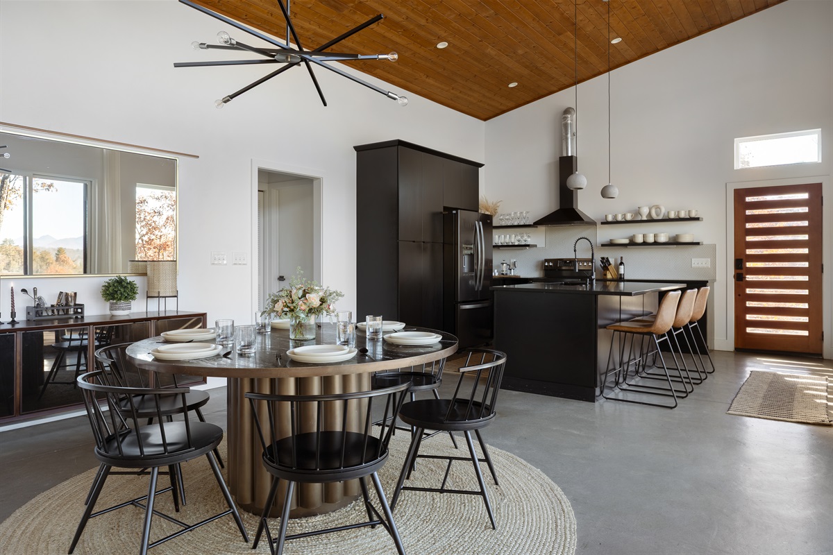 {Kitchen - Glass House} Floor-to-ceiling windows, modern finishes, and a stylish round table ready to serve 10—your group’s favorite gathering spot.