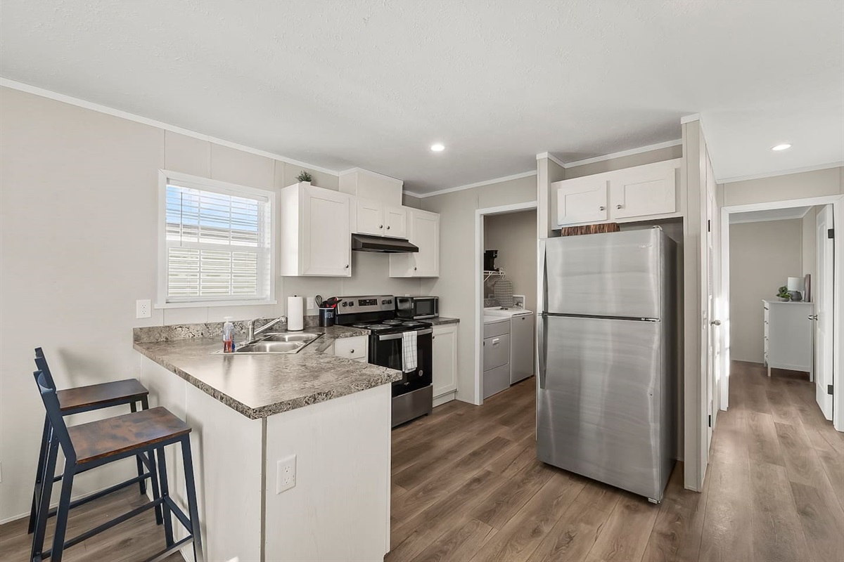 Open kitchen with bar seating and nearby dining area—great for casual meals and staying connected with your group.