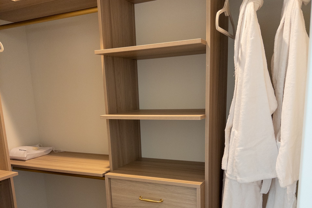Unpack into a custom walk-in closet with built-in shelving and plush robes waiting on the rail.