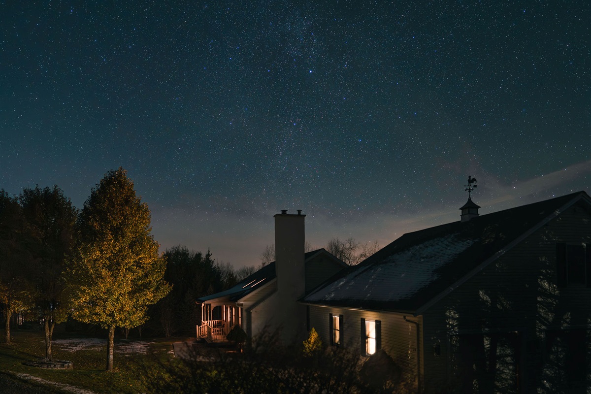 Nighttime exterior showcasing the home glowing beneath crystal-clear stars.