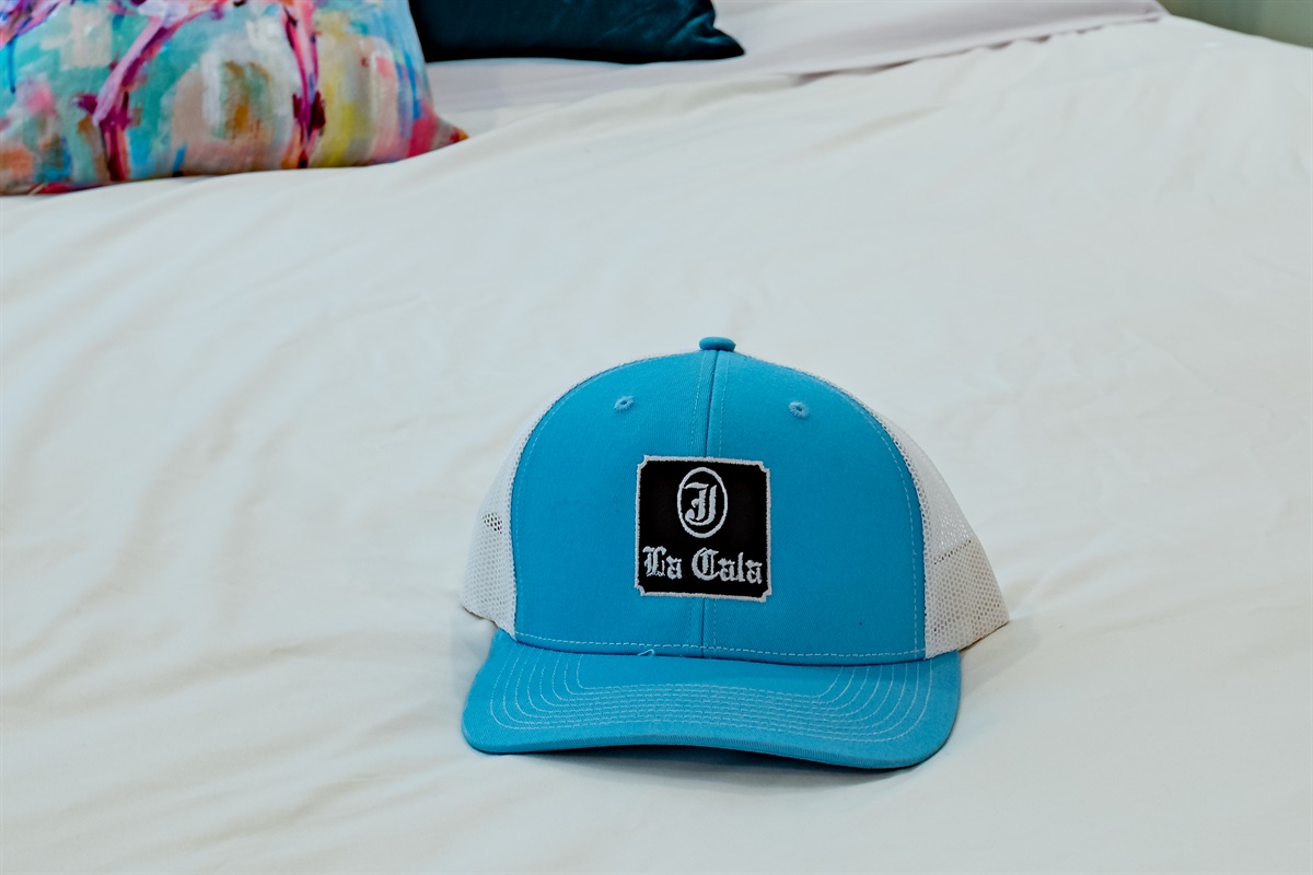 Unique Touch: Discover your vacation vibe with this stylish La Cala hat on a pristine bed!