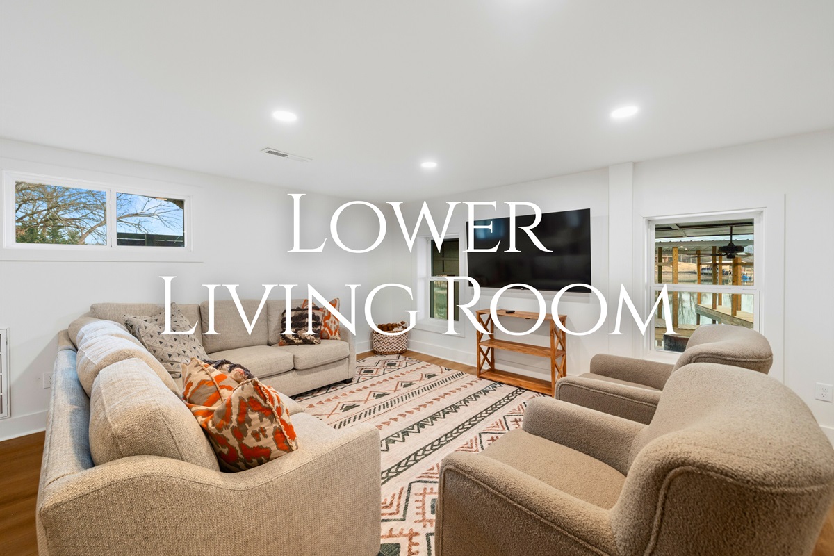 Located on the lower level, the second living room offers a relaxed space with plenty of seating for movies, games, or quiet downtime.