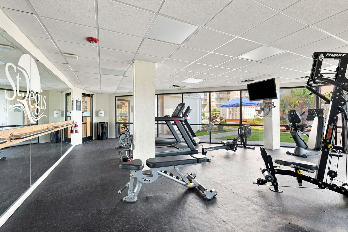 Well-maintained gym facility featuring workout equipment, mirrored walls, and exercise machines for your daily routine.