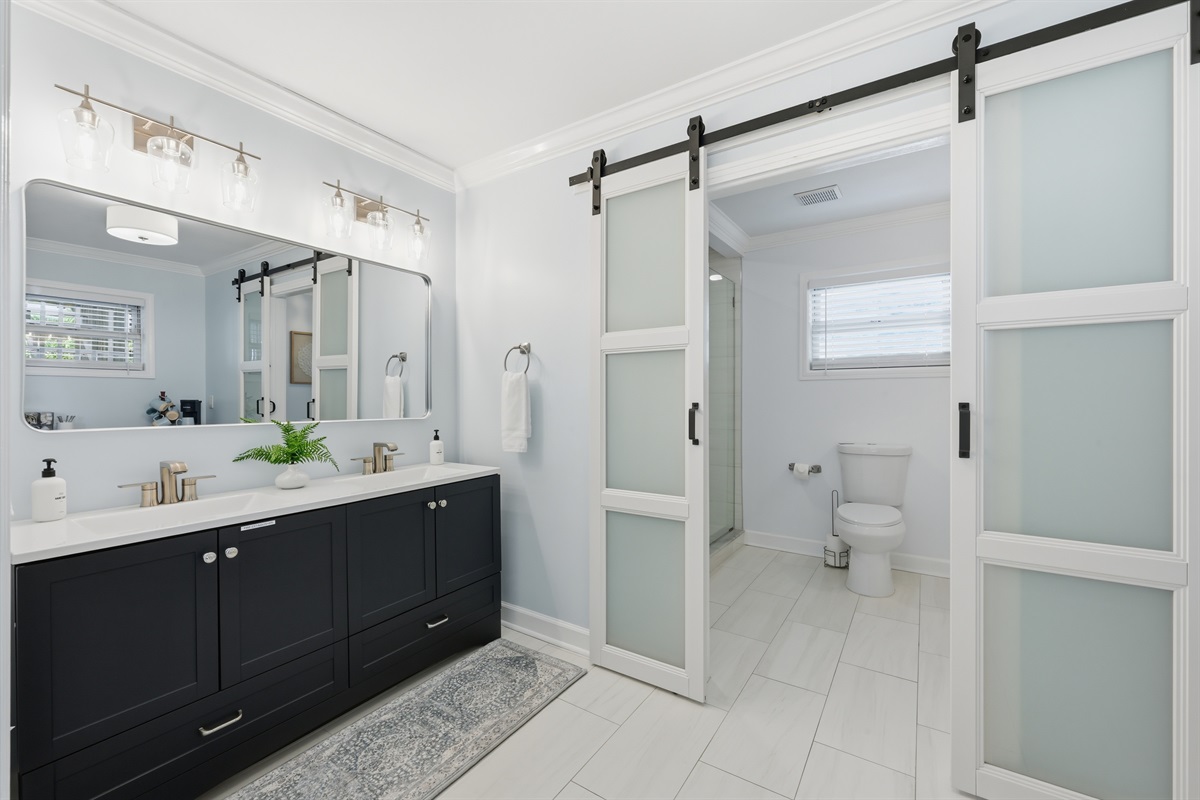 Spa-like primary bathroom with dual vanity and elegant finishes