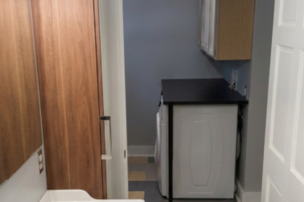 First floor bathroom toward bathroom door with laundry area across the hall near rear door