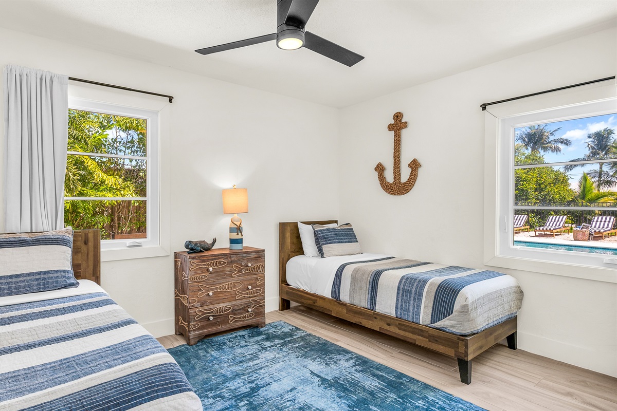 Bedroom 4 features cozy twin beds with nautical-inspired decor and soft coastal tones, perfect for kids, friends, or guests seeking a bright and cheerful space to unwind.