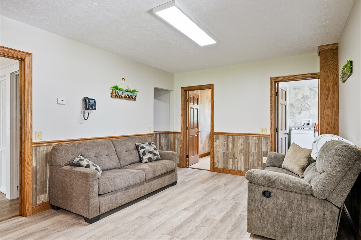 Spacious open-concept living and dining area with natural light, comfy recliners, and a seamless flow into the kitchen. Ideal for entertaining!