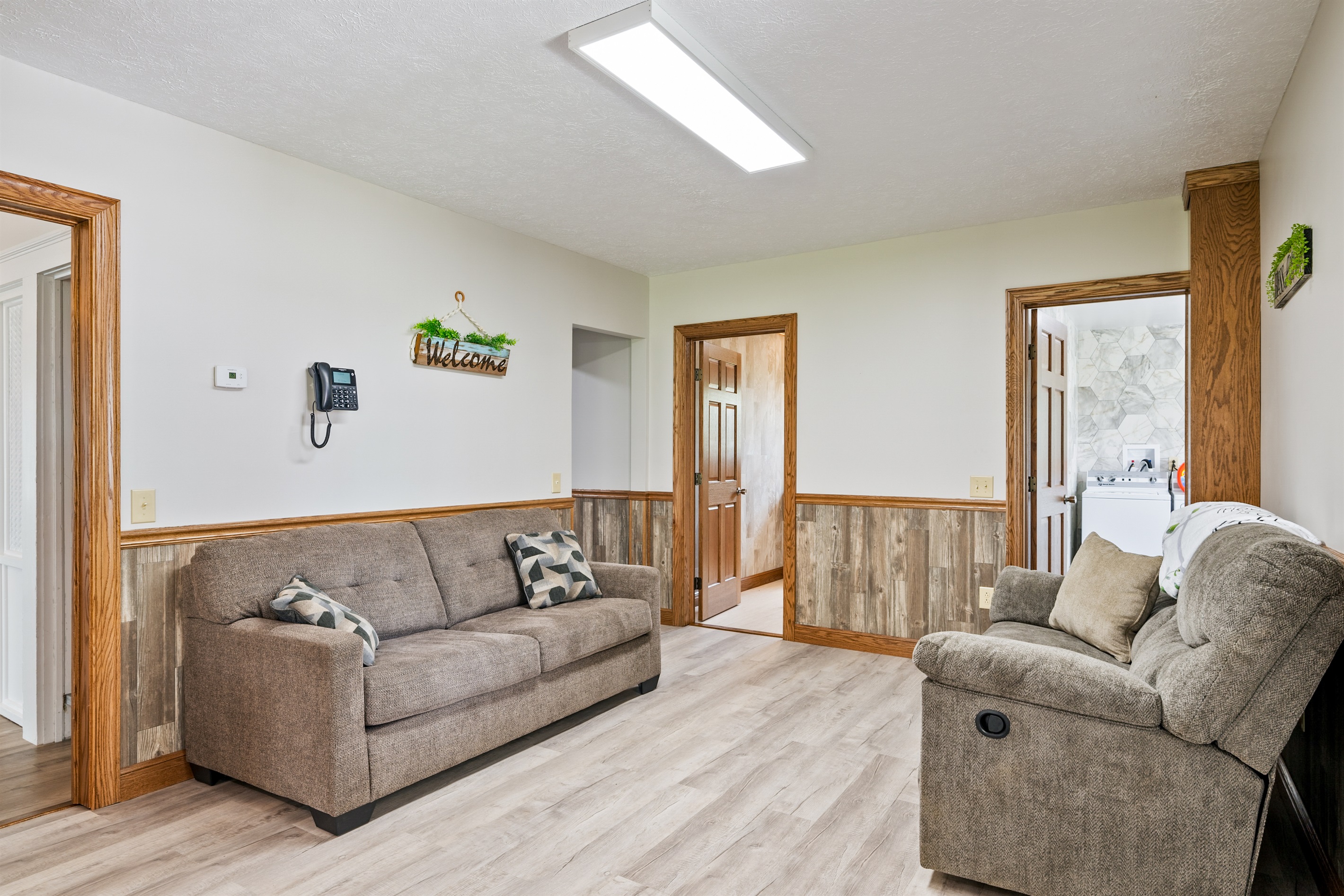 Spacious open-concept living and dining area with natural light, comfy recliners, and a seamless flow into the kitchen. Ideal for entertaining!