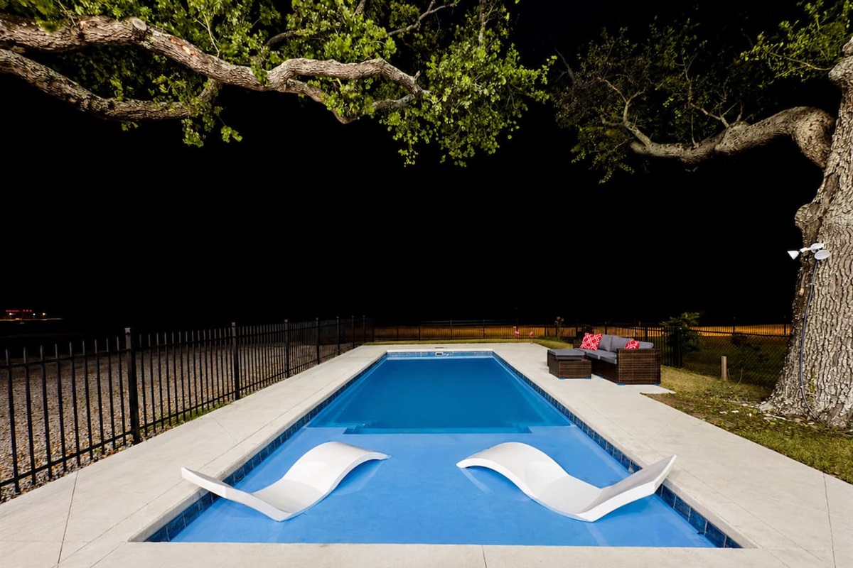 Relax poolside as the night sky sets a calming tone.