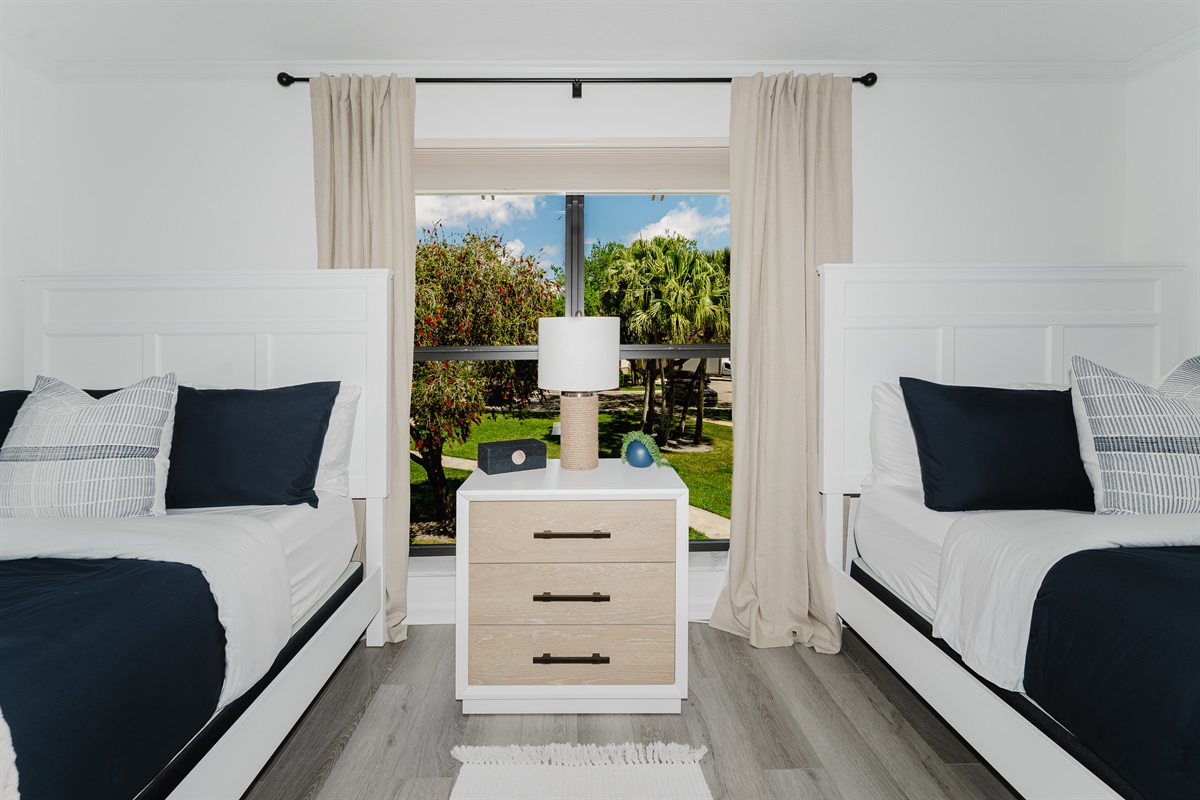 Cozy guest double queen bedroom with comfortable bedding and ample storage. Perfect space for family or friends to unwind and relax. Bright and inviting guest room with stylish touches.