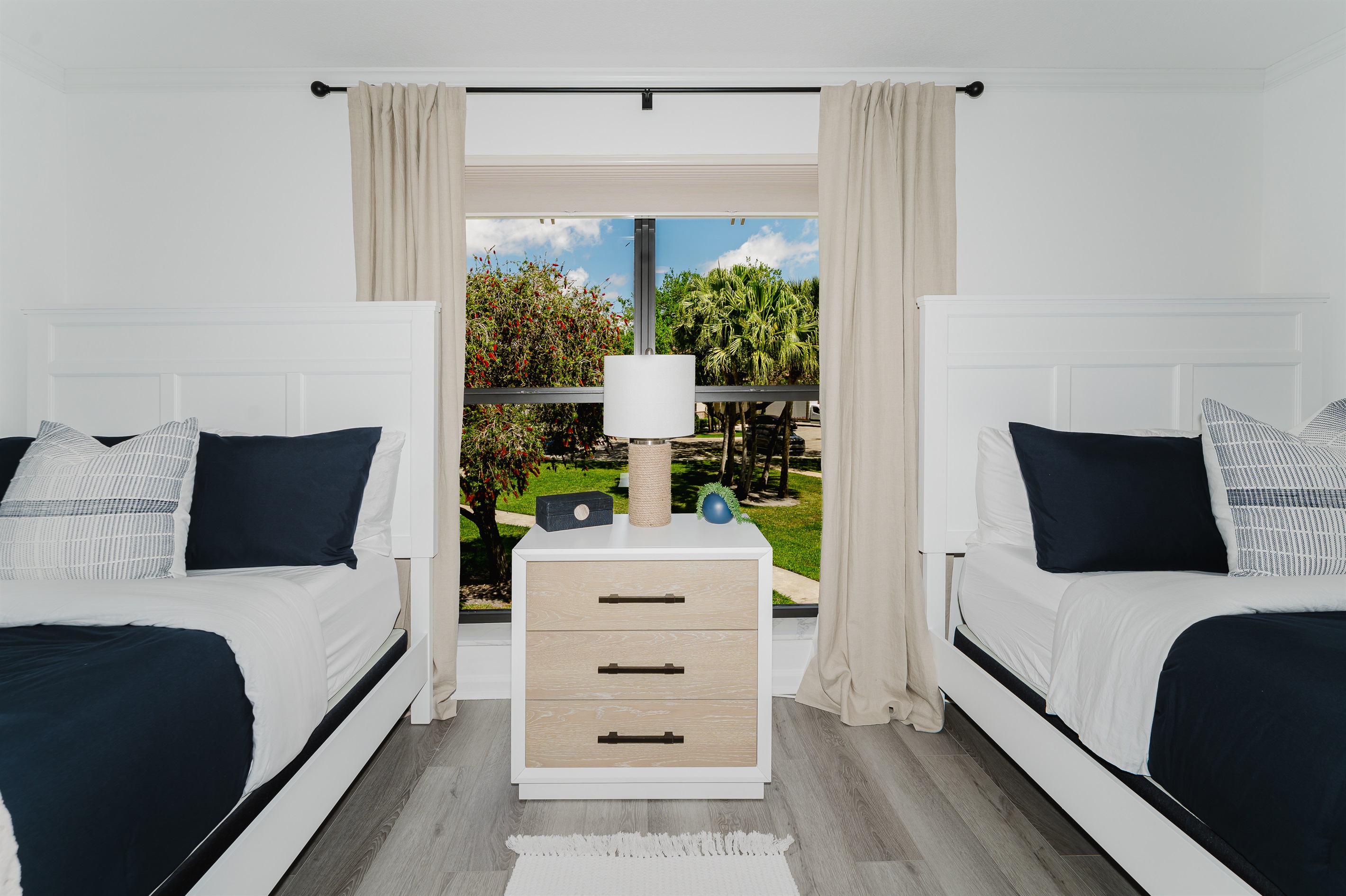 Cozy guest double queen bedroom with comfortable bedding and ample storage. Perfect space for family or friends to unwind and relax. Bright and inviting guest room with stylish touches.