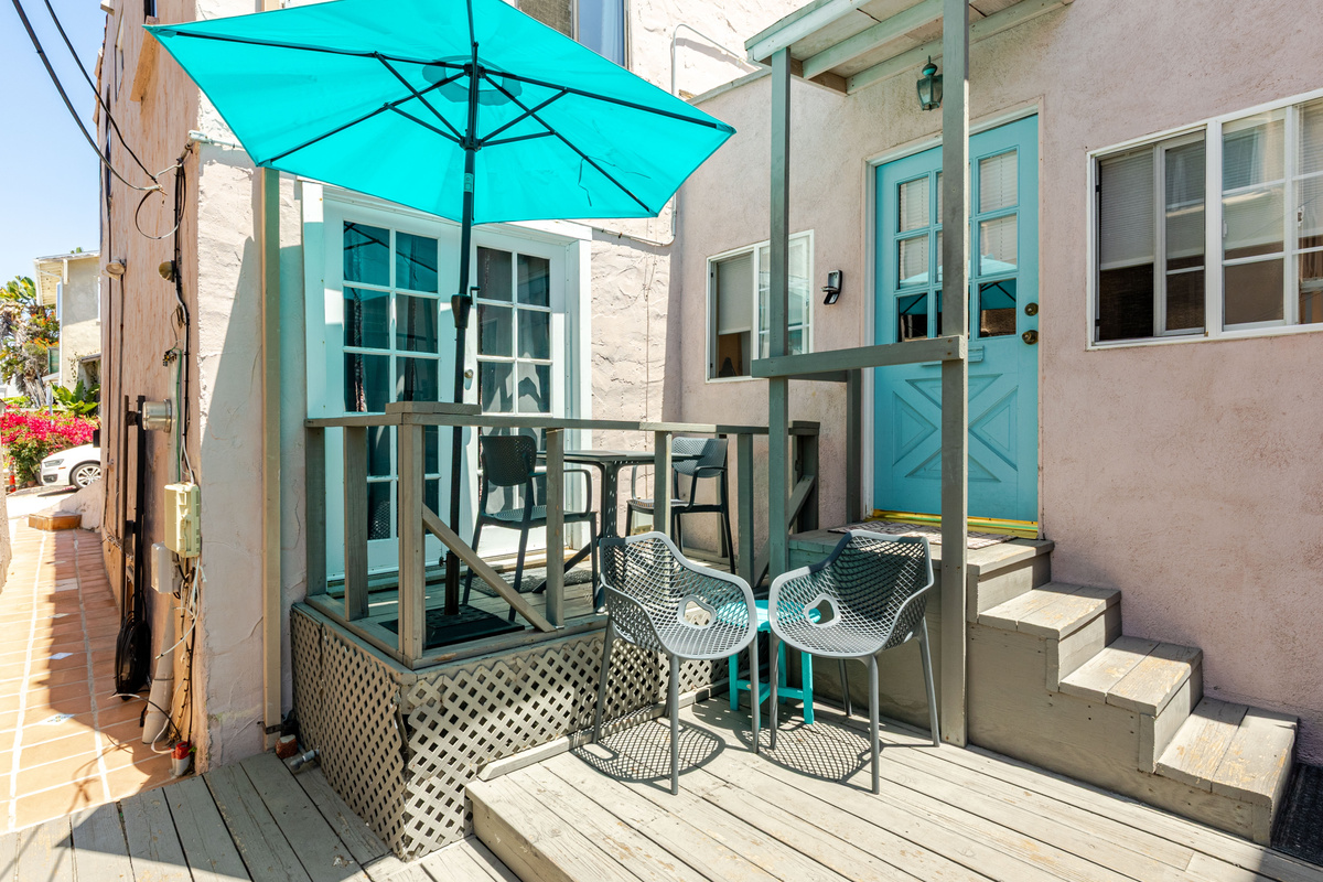 Walk along the west side of the house to access the 400 sq ft wood deck with outdoor furniture and a propane BBQ grill.  The front door to the apartment is up a flight of stairs.