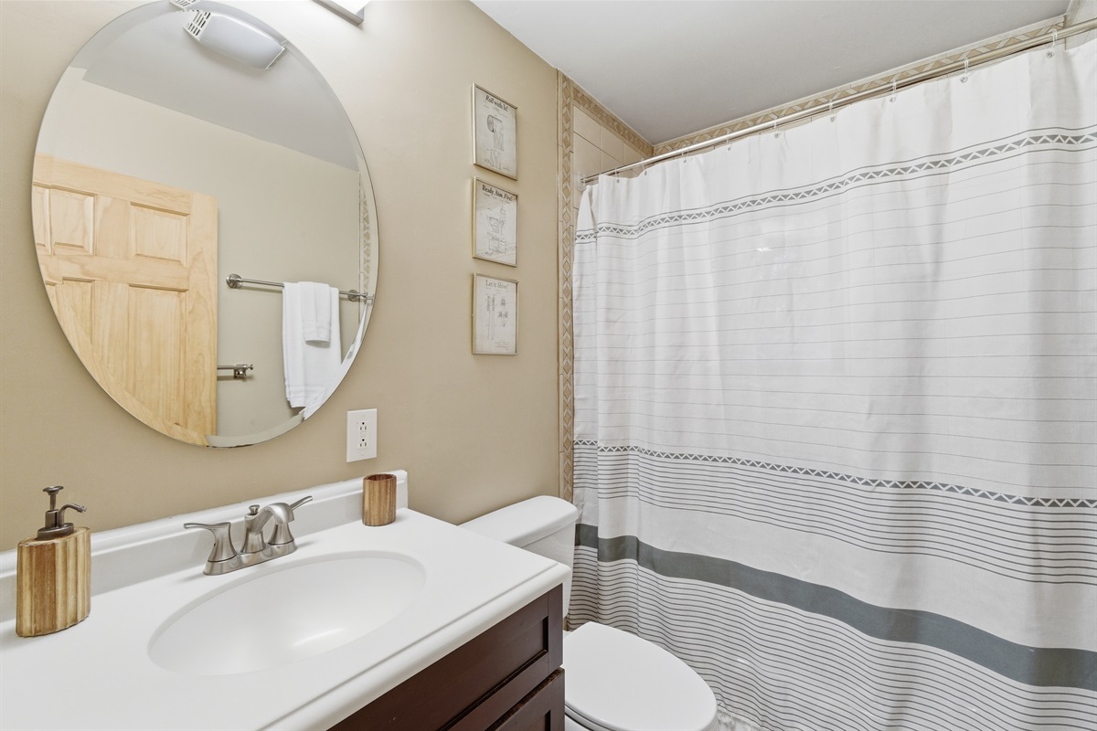 The upstairs bathroom offers a stand up shower and tub combined