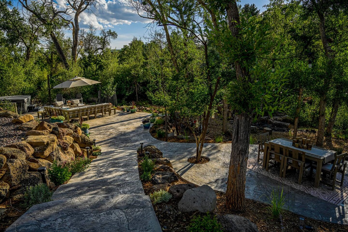 View of the outdoor dining, outdoor seating, and hot tub with direct access to Surface Creek walking path and creek.