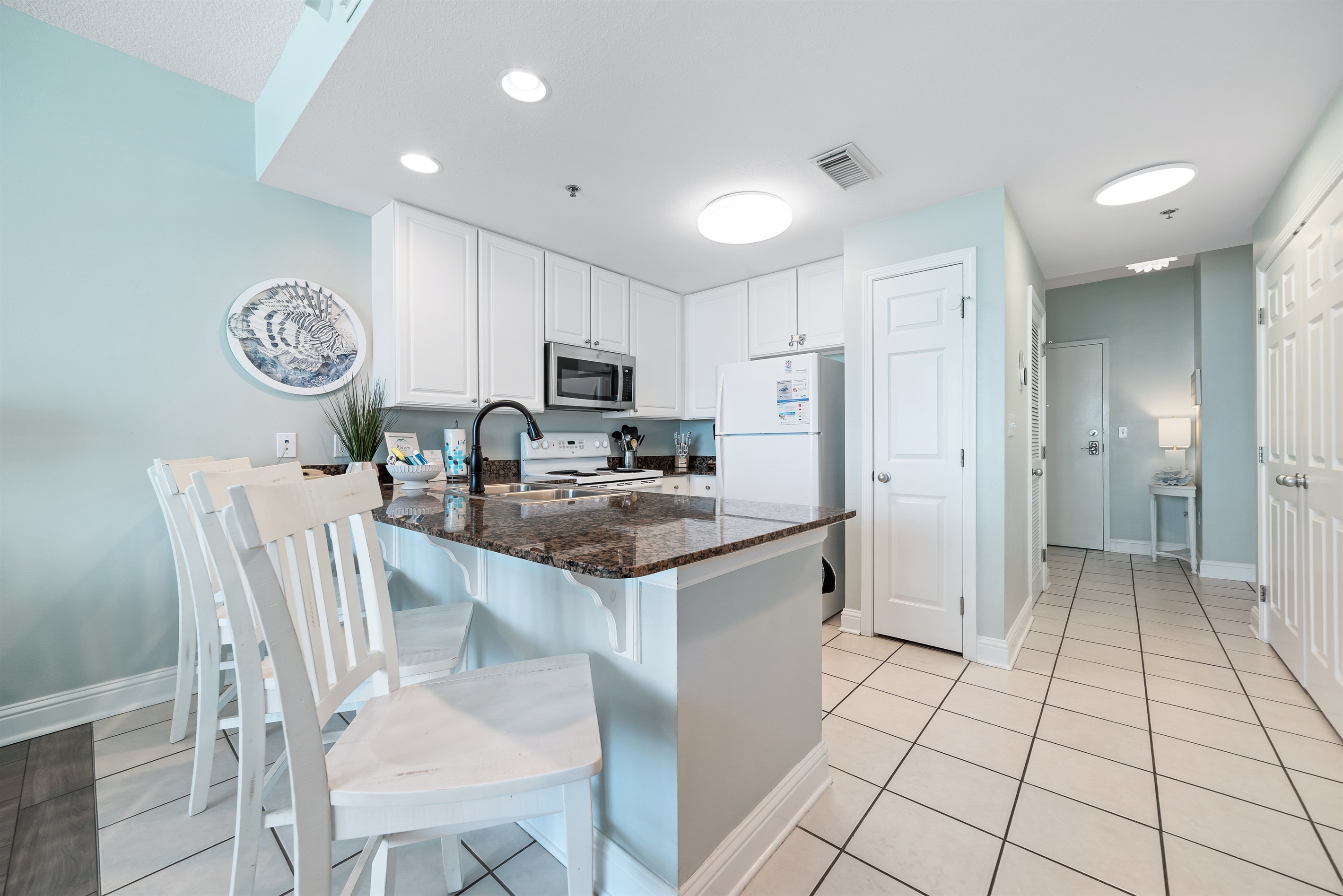 The kitchen island takes center stage, offering ample counter space and casual seating. Perfect for meal prep, entertaining, and everyday living.