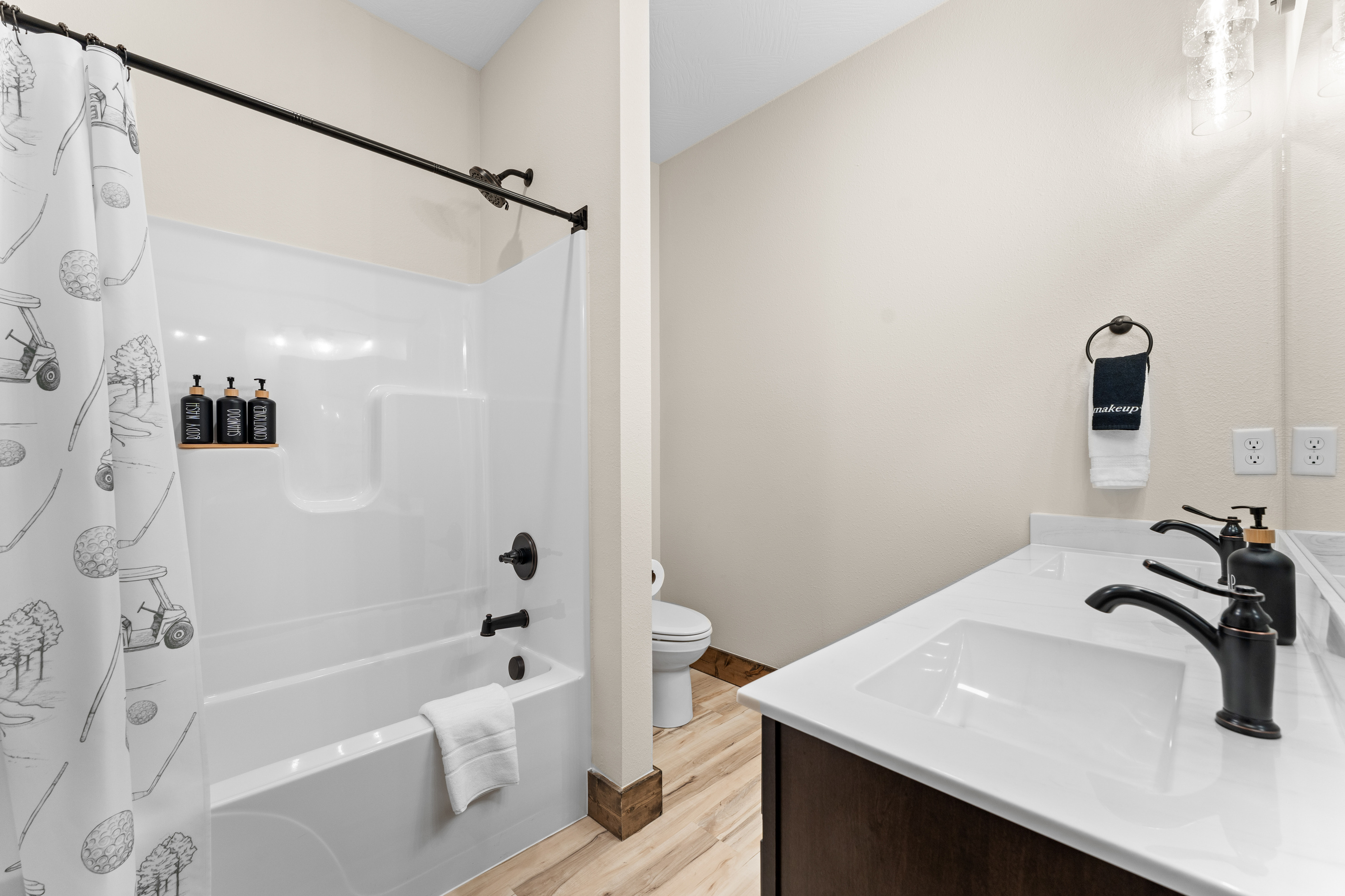 Shower/tub combo that is thoughtfully decorated and appointed.