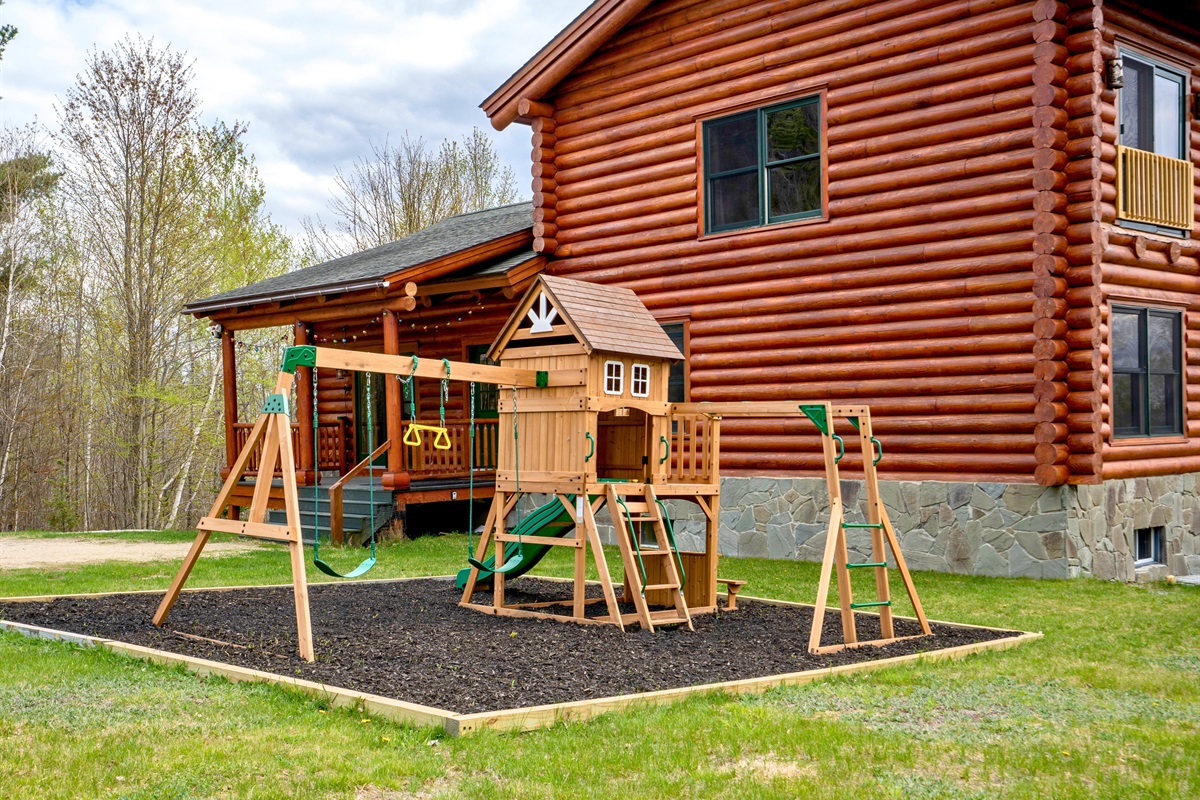A spacious backyard playground designed for endless fun, complete with swings, climbing features, and a slide for little ones to enjoy.