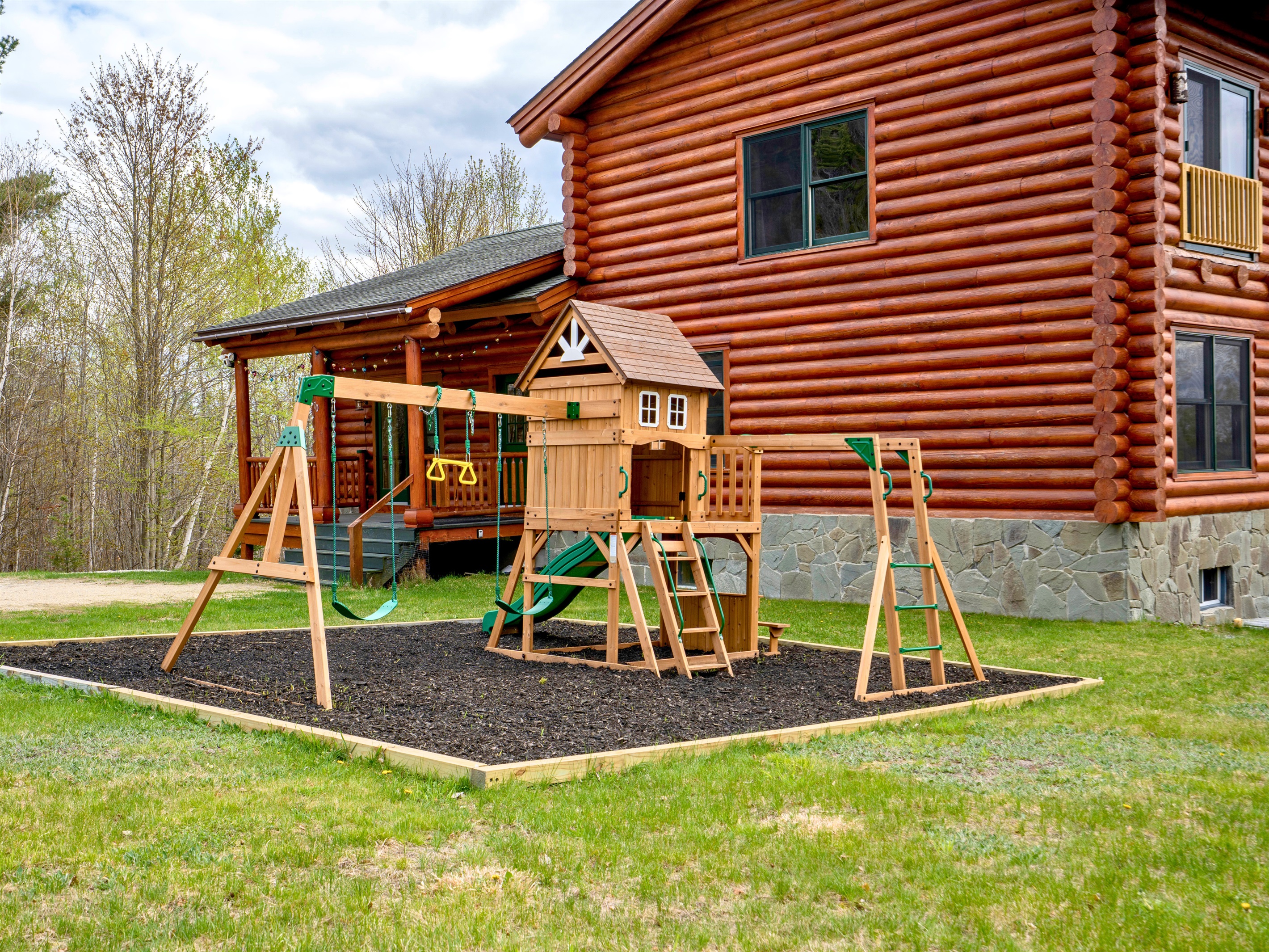 A spacious backyard playground designed for endless fun, complete with swings, climbing features, and a slide for little ones to enjoy.