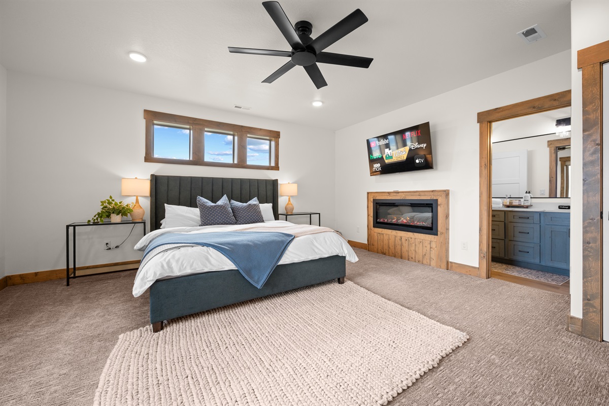Spacious lower-level king suite with cozy fireplace, plush bedding, and direct access to a private ensuite—your perfect retreat after a day at Bear Lake.
