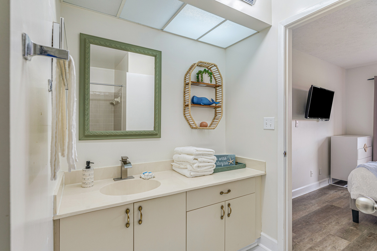 Connected to the primary bedroom, the ensuite bathroom features a bathtub, fresh towels, and all the essentials for a comfortable stay.
