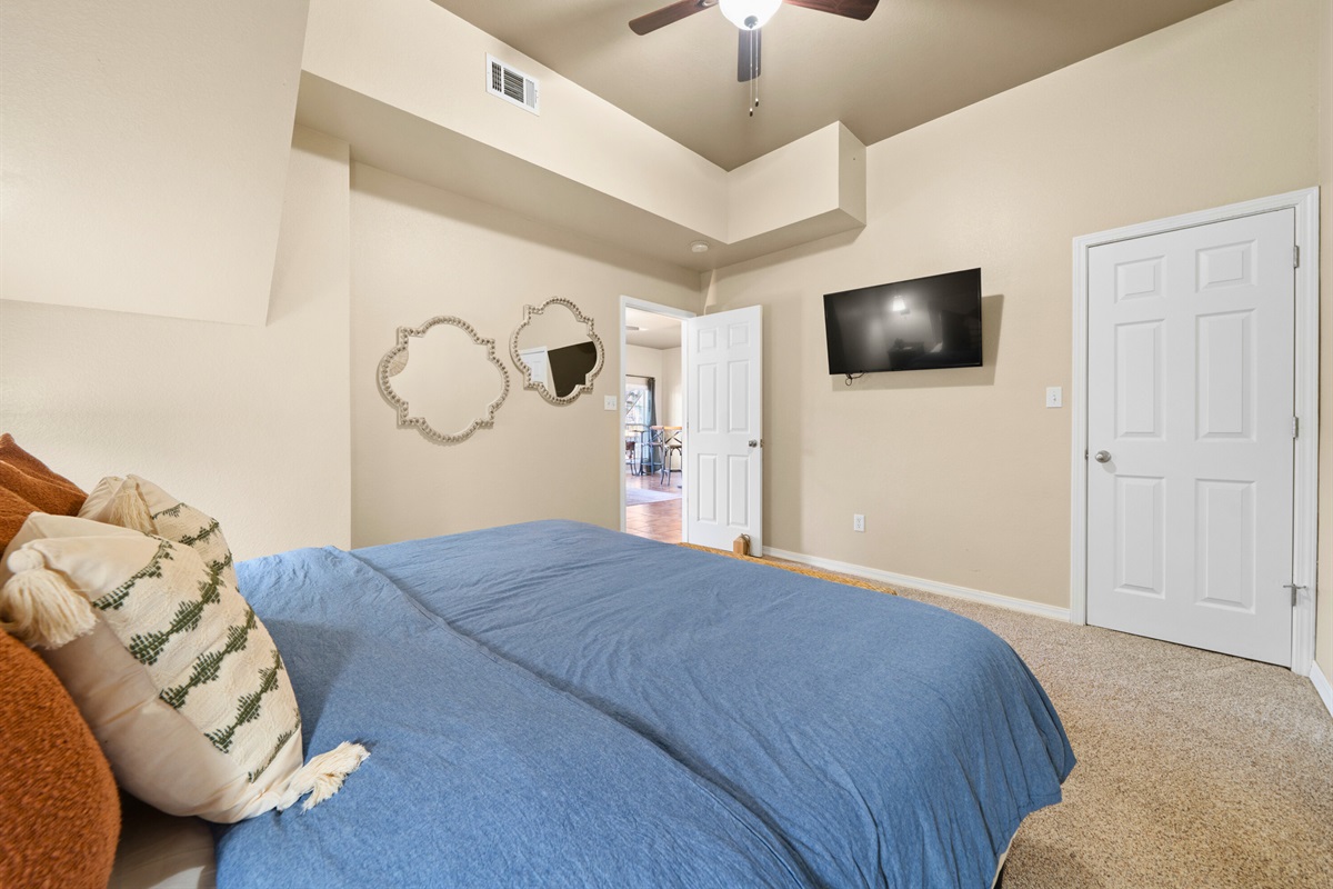 A cozy seating nook and mounted TV make this king room feel like its own private hideaway, perfect for quiet evenings or simply settling in with a good show.