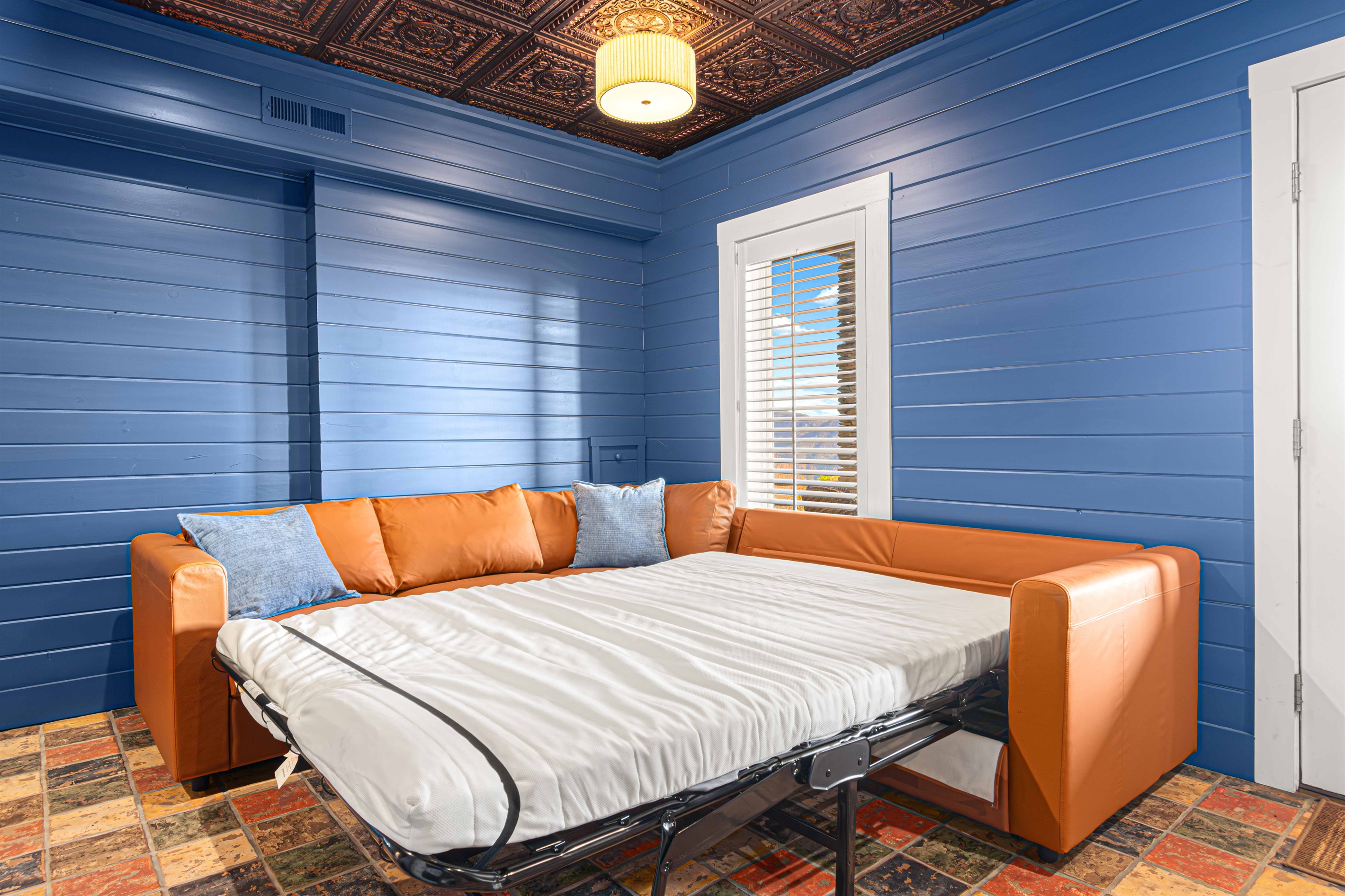 Game Room: Bright blue walls and a chic sleeper sofa invite relaxation and fun together!