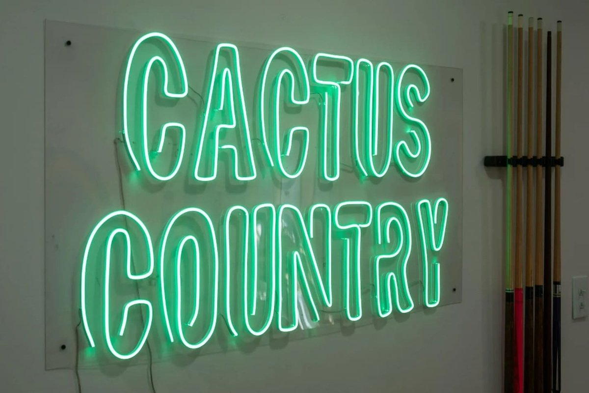A glowing "Cactus Country" sign captures the playful desert spirit that runs through the whole home.