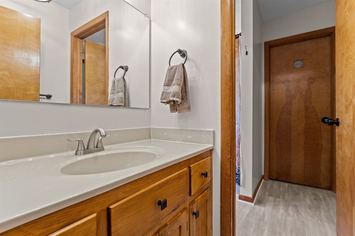 Bathroom Oasis: Brightly lit space with sleek fixtures and a touch of rustic charm awaits!